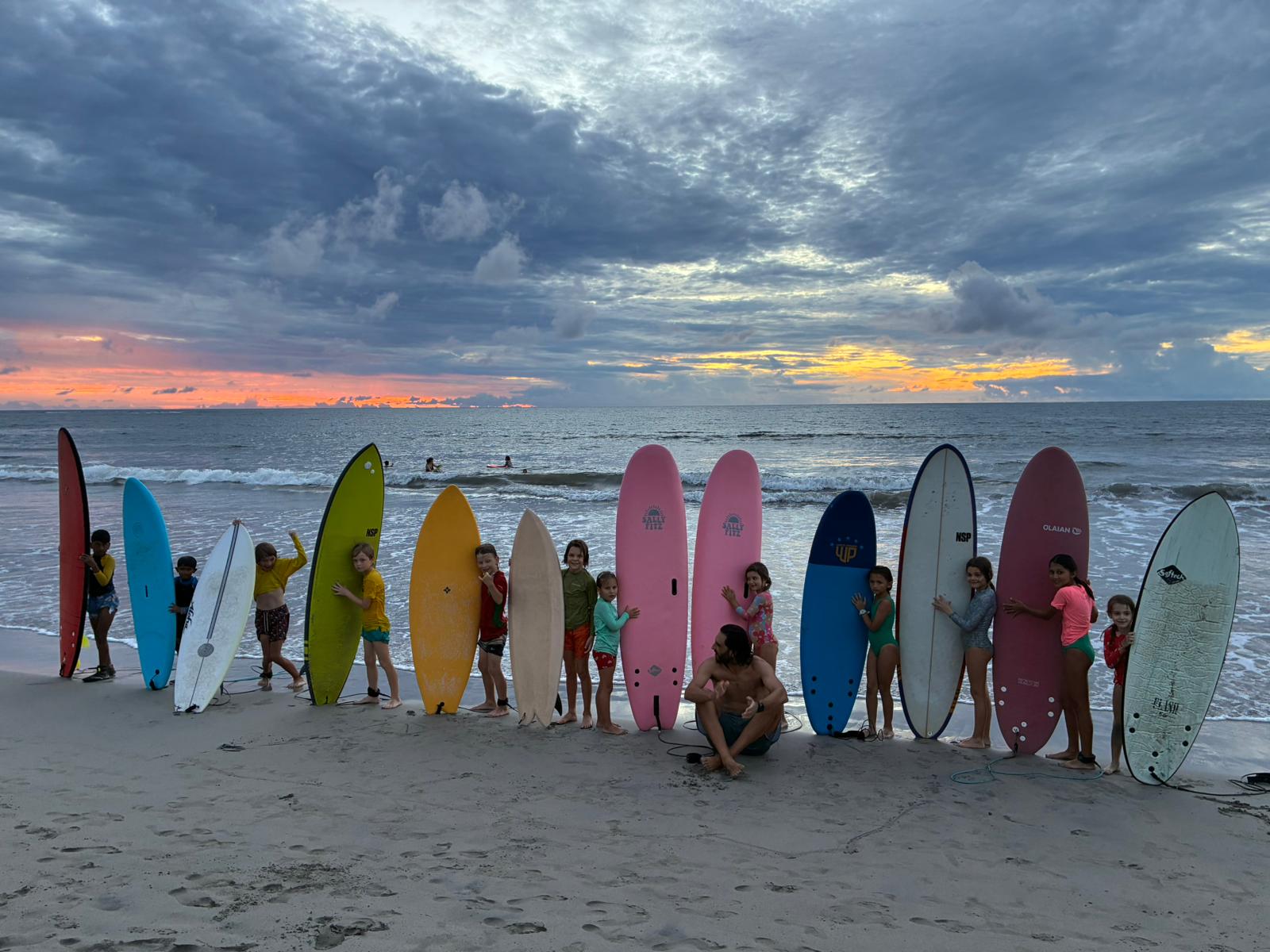 Young surfers standing with their boards at the shoreline in Tamarin.