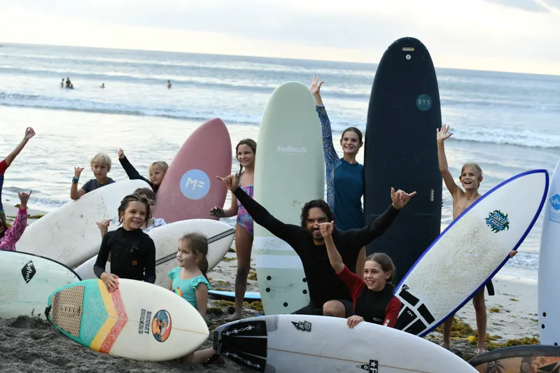 The whole club with their boards on Tamarin beach after Cup Vol. 01, arms up.